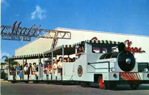 a small train ride transports shoppers underneath the old plaza mall sign