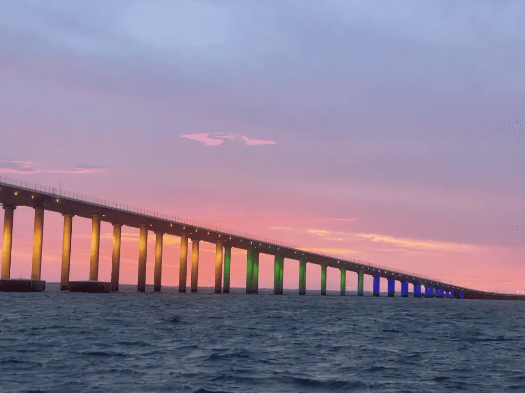 sunset view of a long Bridge on the water