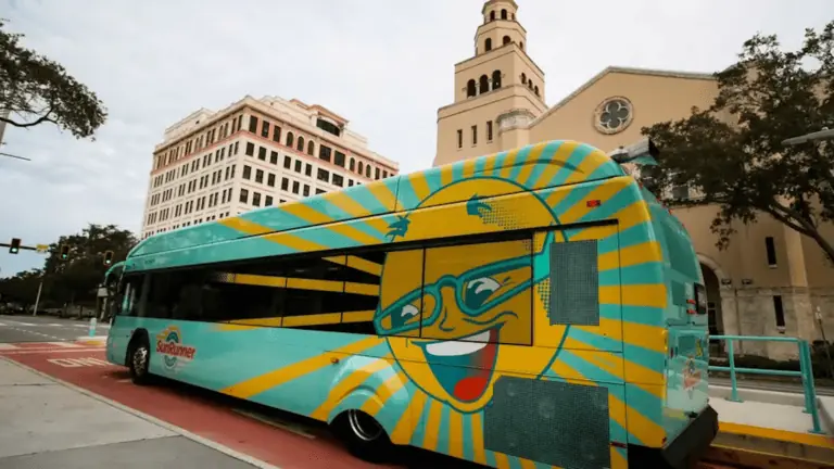 exterior of a bus with a smiling yellow sun outside