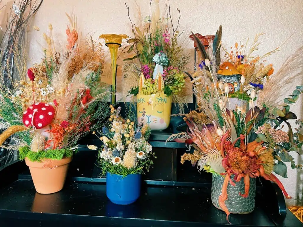 Dried floral bouquets inside decorative pots at Bloom House