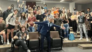 A presenter posing with a college class