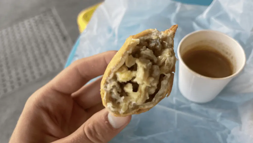 Empanada next to a shot of espresso on an outdoor table