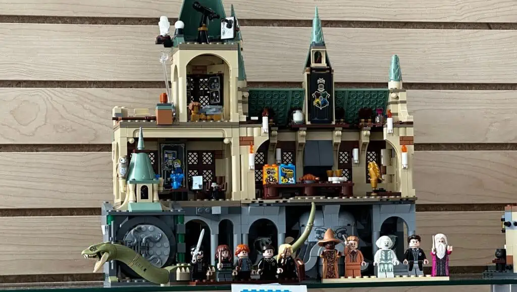 a LEGO castle with a large snake in front
