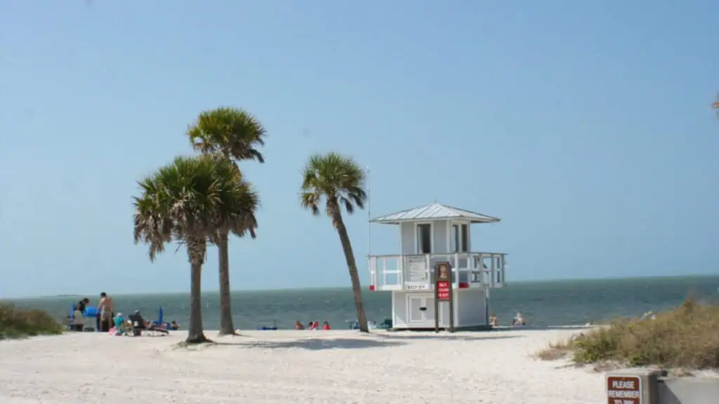 a beach at sunrise with a life guard tower at the center 