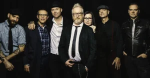 The band flogging molly poses together on a black background