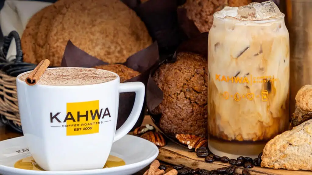 Two new fall drinks from Kahwa Coffee sit on a board: The GOlden hour latte and a harvest chai