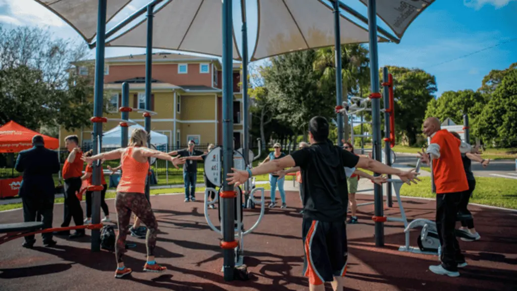 a group of people gather at an outdoor gym facility