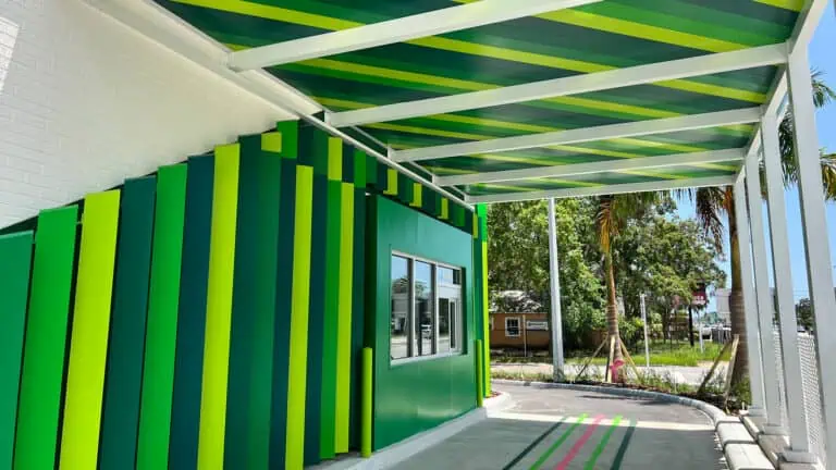 a drive thru with a green enclosure