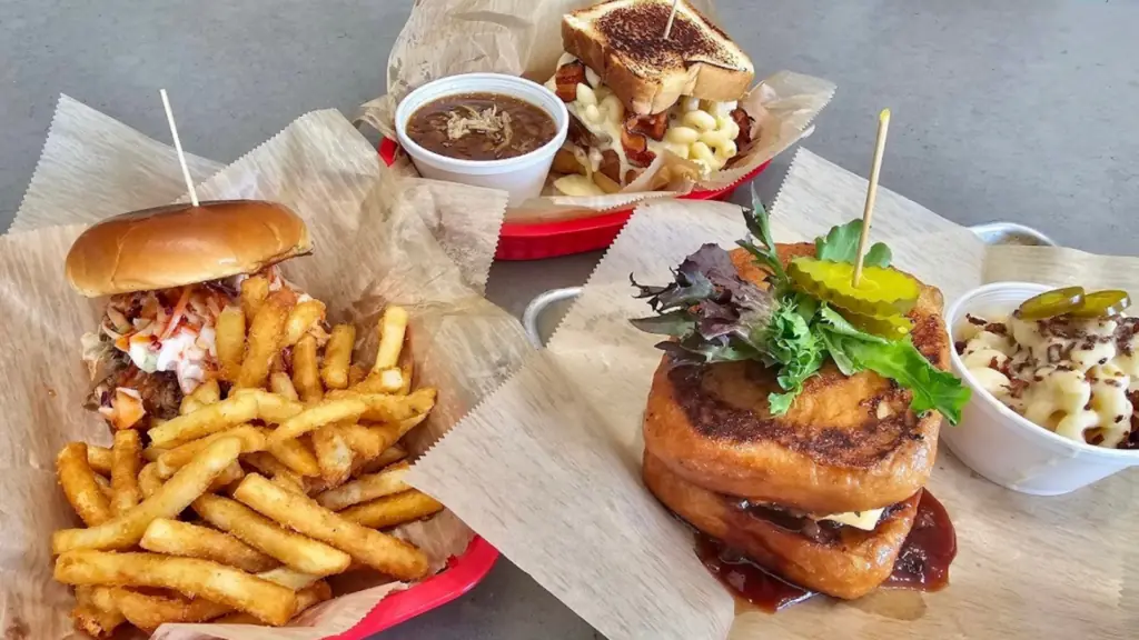 Several sandwiches with various side dishes