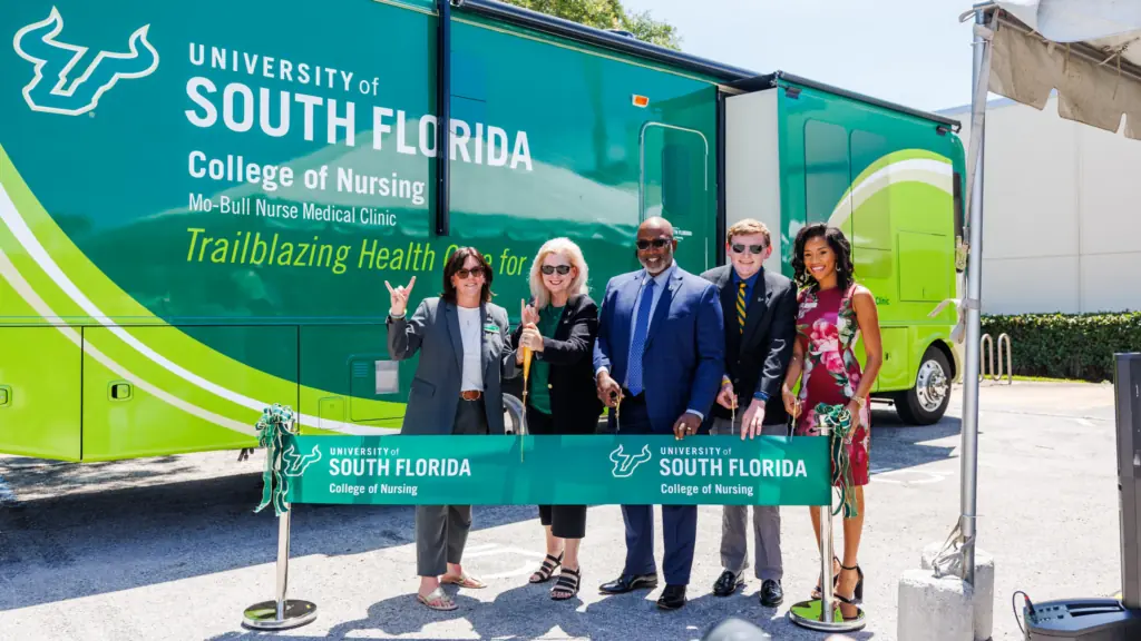 Leaders posing in front of a bus