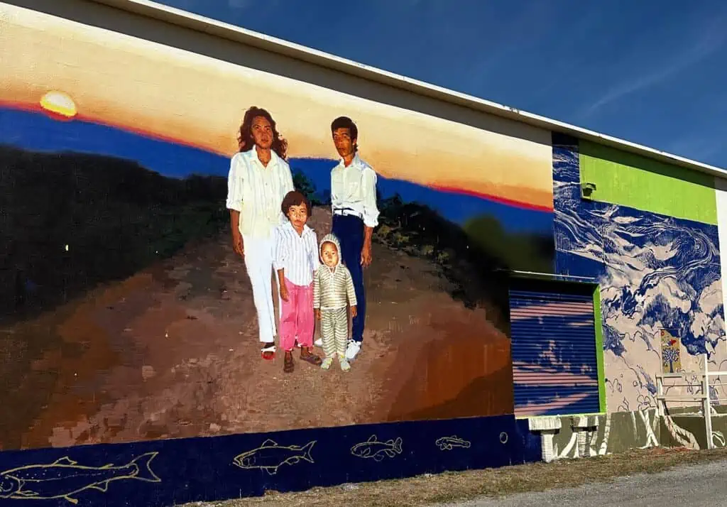 a mural portraying a family of 4 standing in the road