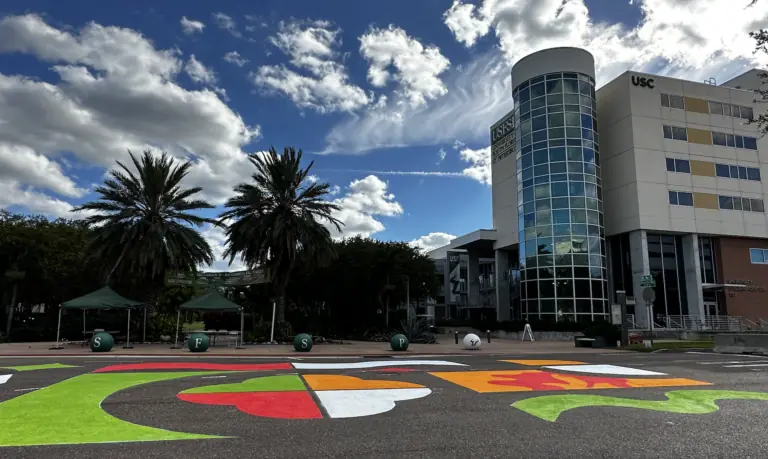 a red and green street mural outside a college campus