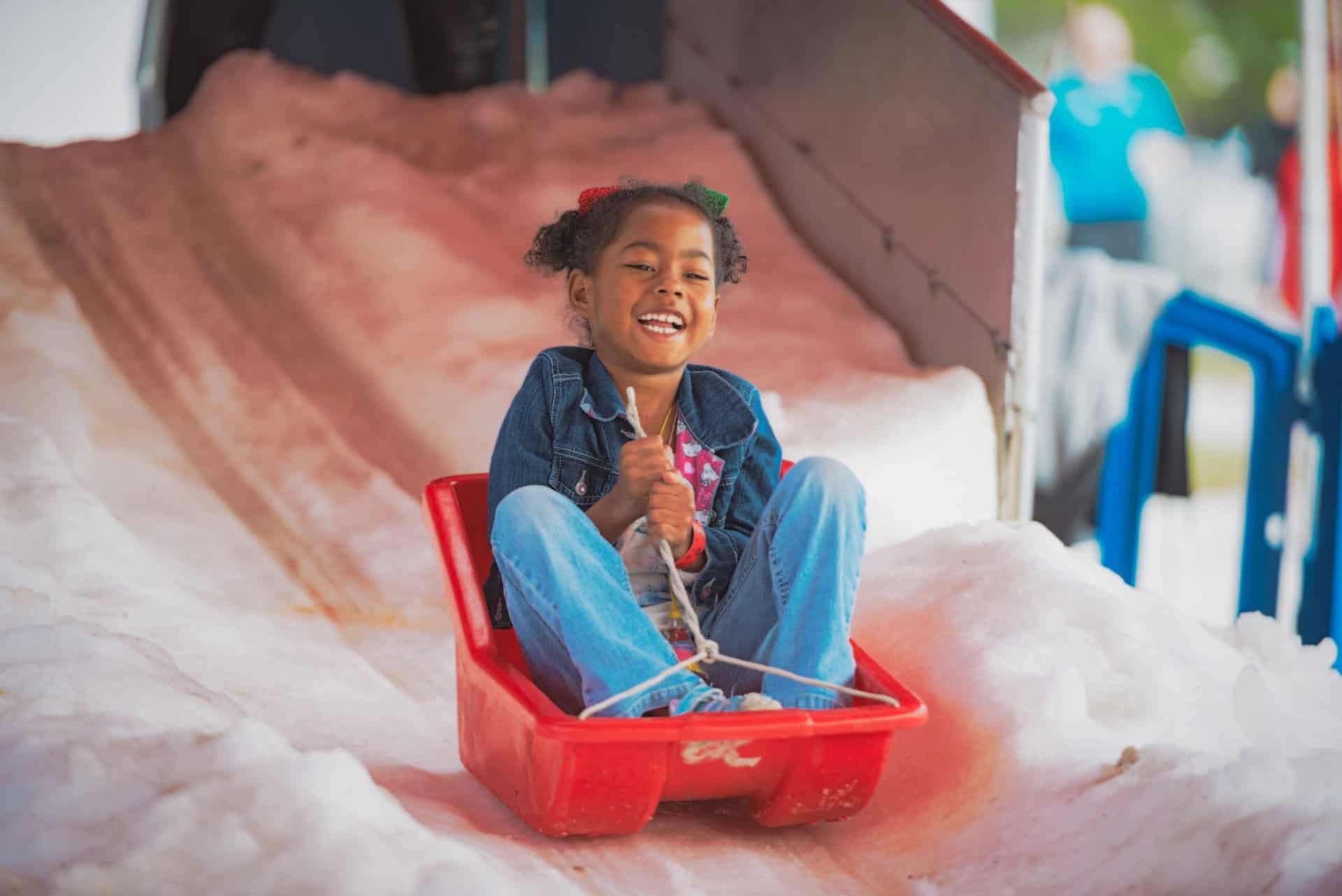 young girl riding on a sled