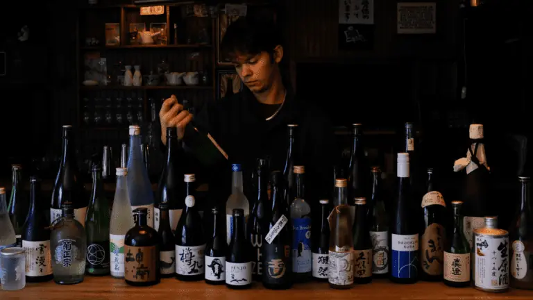 A bartender surrounded by sake bottles
