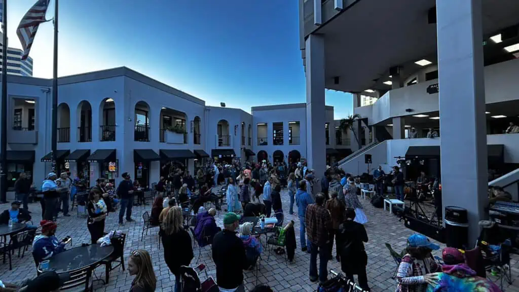 a courtyard with people heading toward a music stage