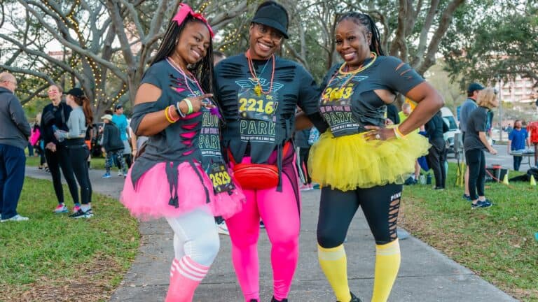 Three runners in colorful outfits ready for an evening run on the waterfront