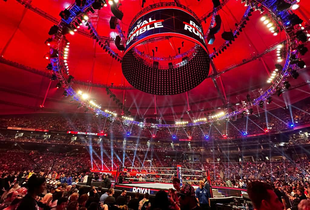 a wrestling ring and a large screen above the ring