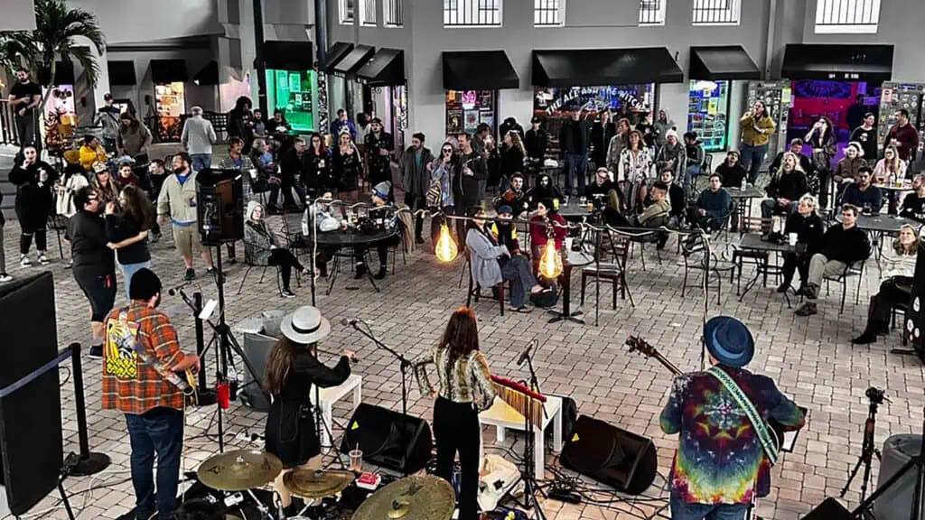 a band performs live on a stage in a big courtyard