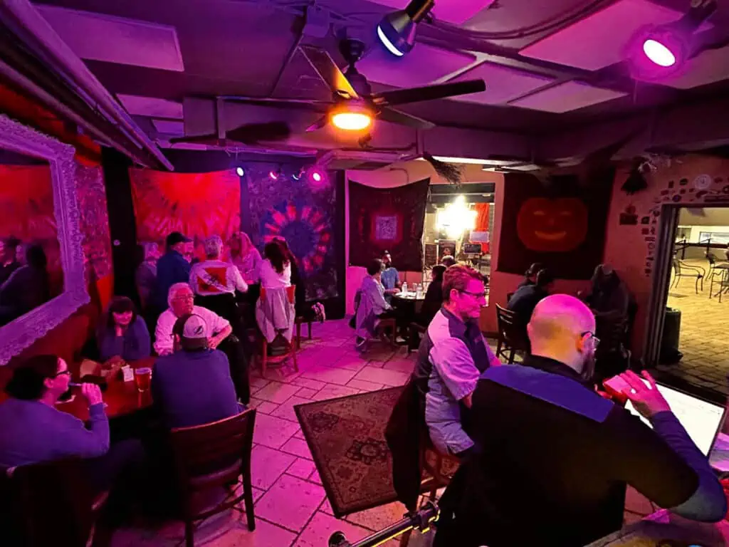 inside a bar with soft pink lights and tapestries on the wall