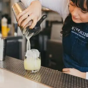 a bartender pours a margarita