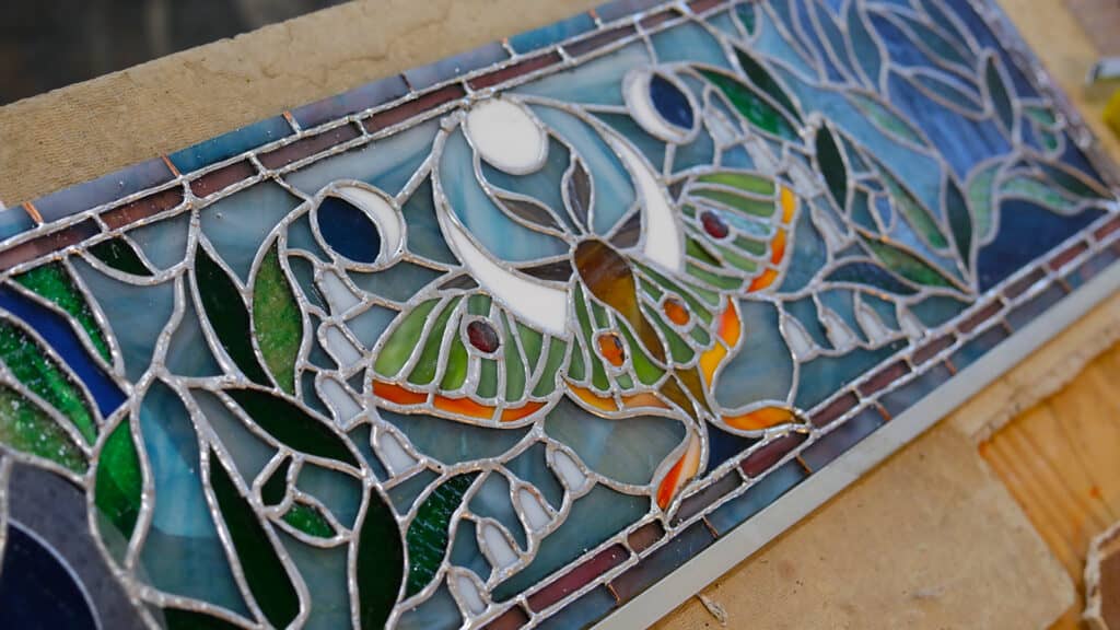 a butterfly and lunar cycle stained glass art piece