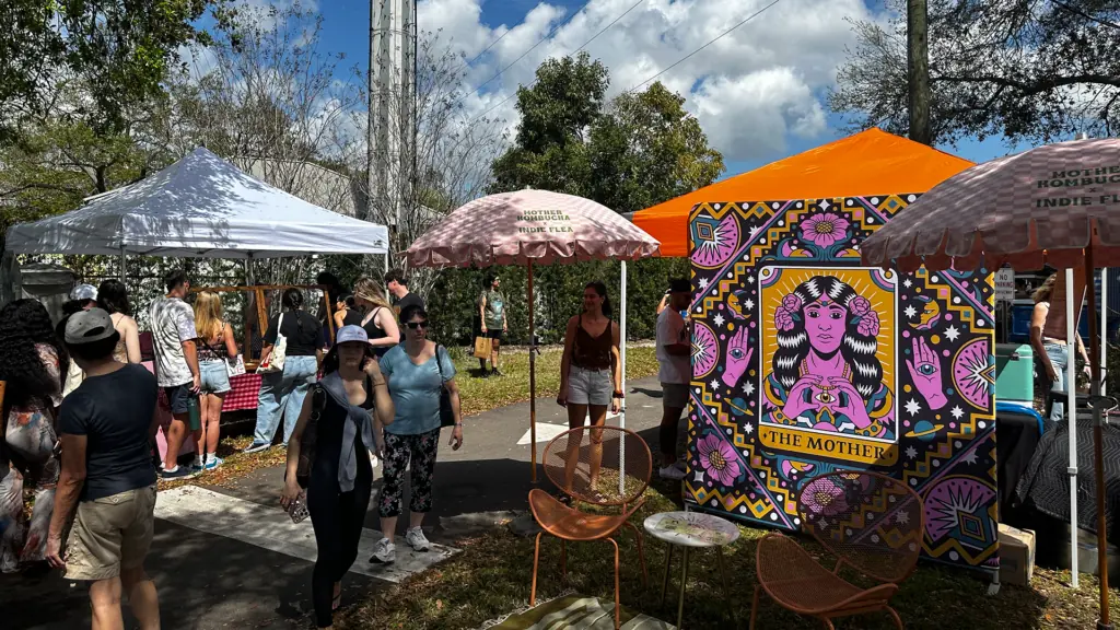 vendor tent with a pink and orange tapestry 