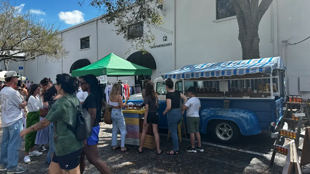 a food truck carrying local raw honey is set up outside a building
