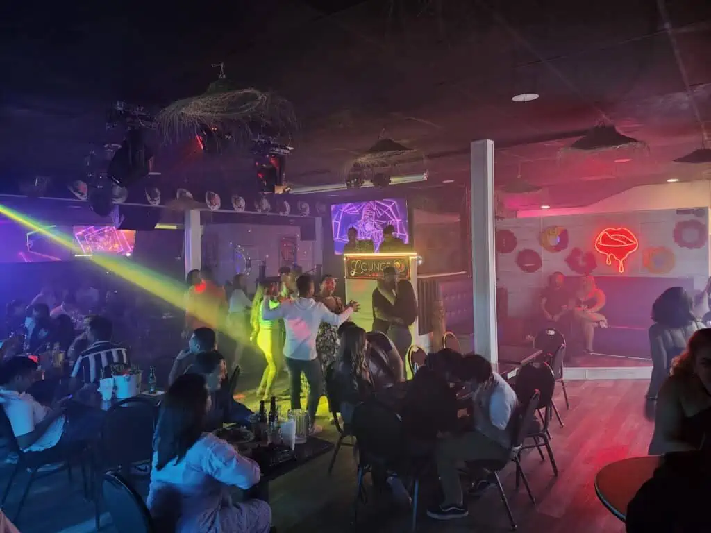 Neon lights inside a club with people dancing