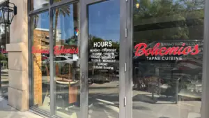 exterior of a restaurant with a red restaurant sign that reads "Bohemios"