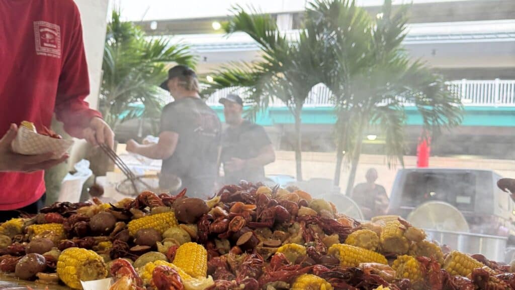 Crawfish, corn, shrimp, sausage, and potatoes heaped on top of a table.