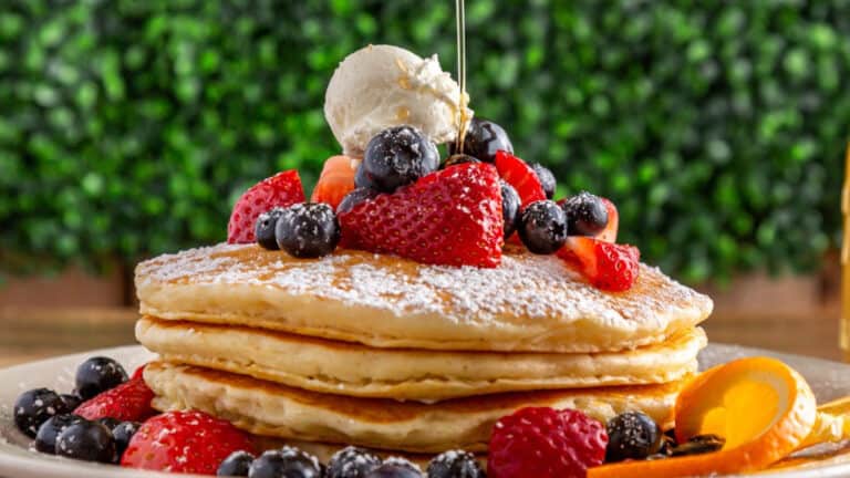 Plate of stacked pancakes with fruit toppings
