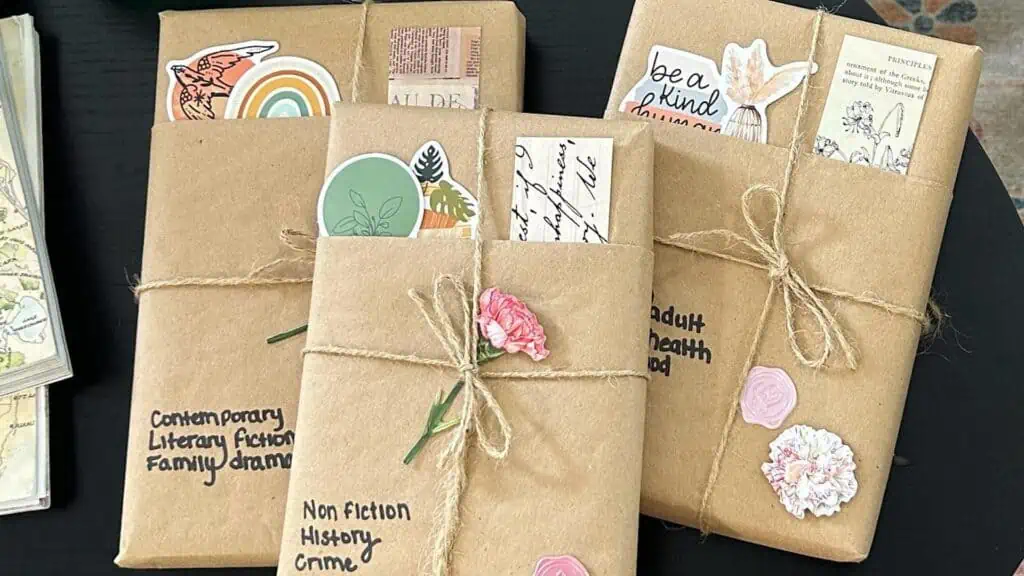 three books wrapped in brown paper and decorated with stickers