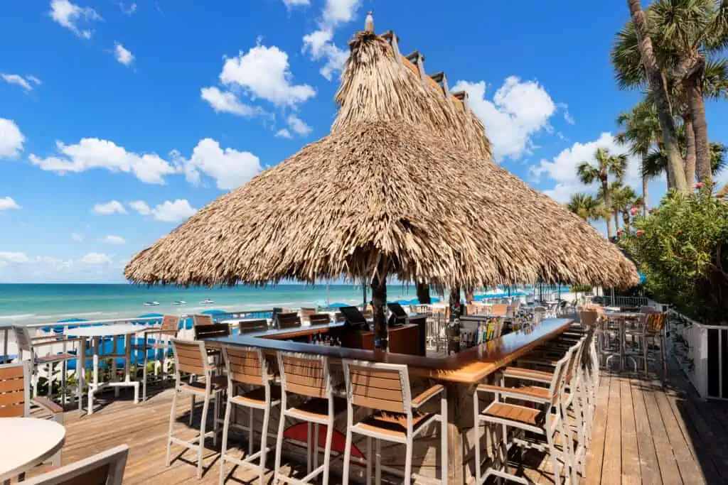 Coconut Charlie's outdoor rectangle shaped bar with thatch style roof and views of the Gulf