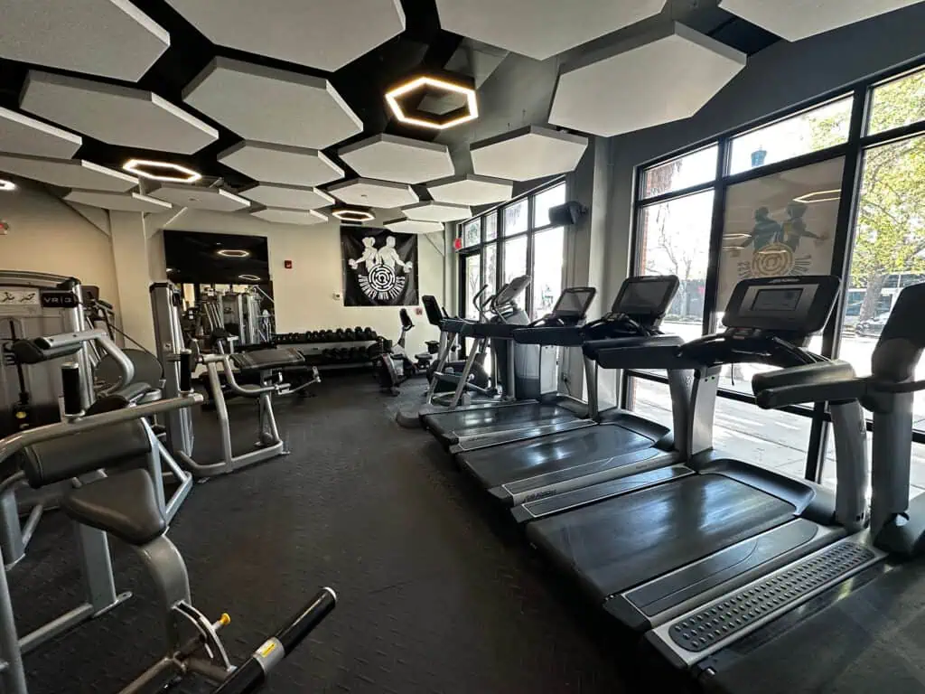 interior of a gym with treadmills and free weights visible