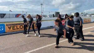 students line up for a foot race on the grand prix pit lane track