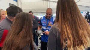 A mechanic shows students the driver's wheel and all the buttons it has