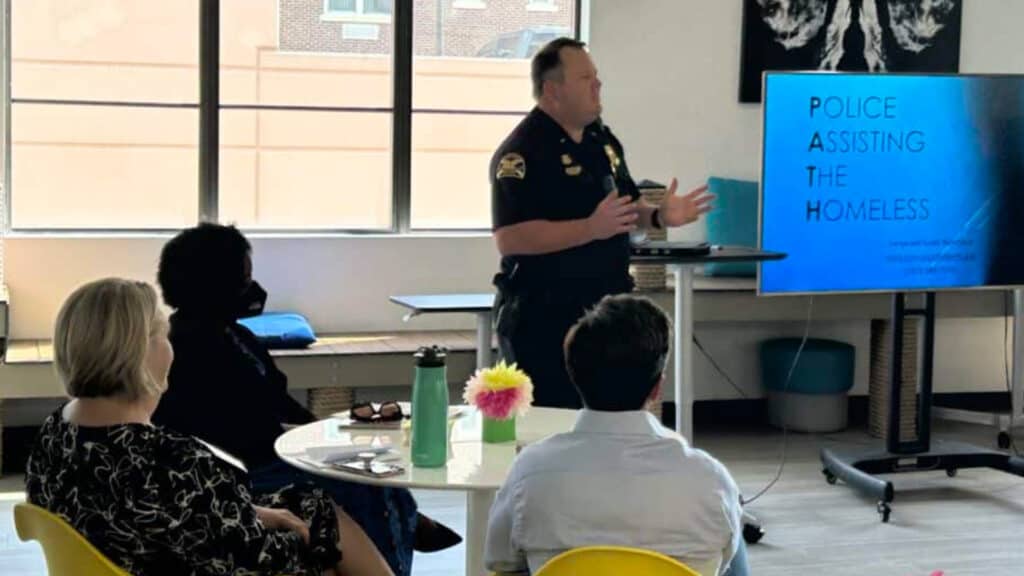 Police officer standing in front of screen facilitating discussion in front of audience