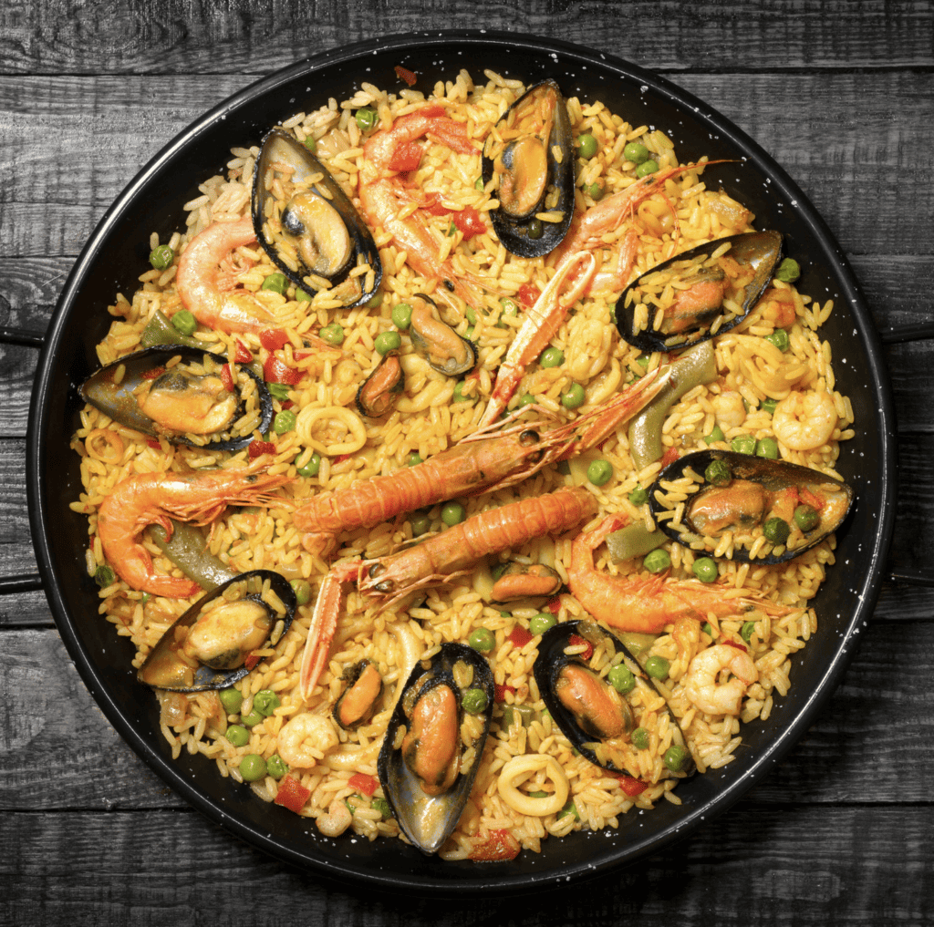 Bohemios paella with yellow rice and seafood including prawns and muscles. 