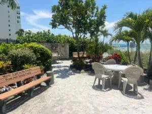 wooden benches set up next to a beach front garden