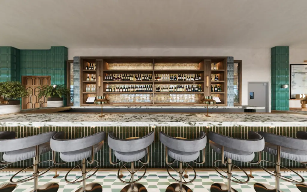 Another view looking directly at the sparrow bar with green tile, marble bar, liquor bottles and row of seating.