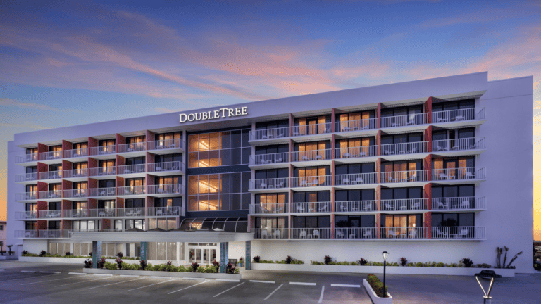 View of the front of the newly remodeled DoubleTree North Redington Beach. A 7 floor hotel with 125 rooms with a sunset sky in the bacdrop.