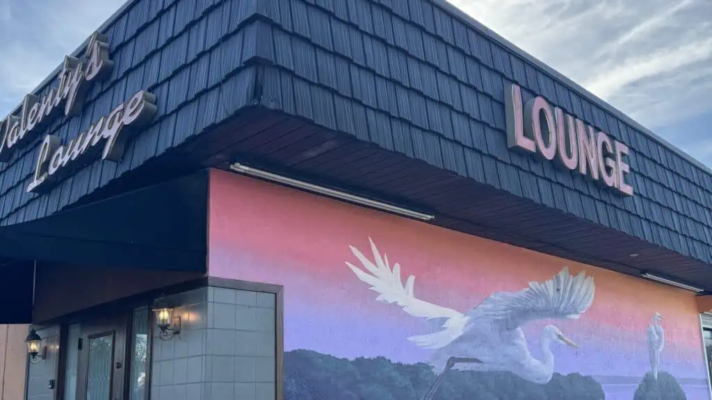 exterior of a bar/liquor store with a mural on it