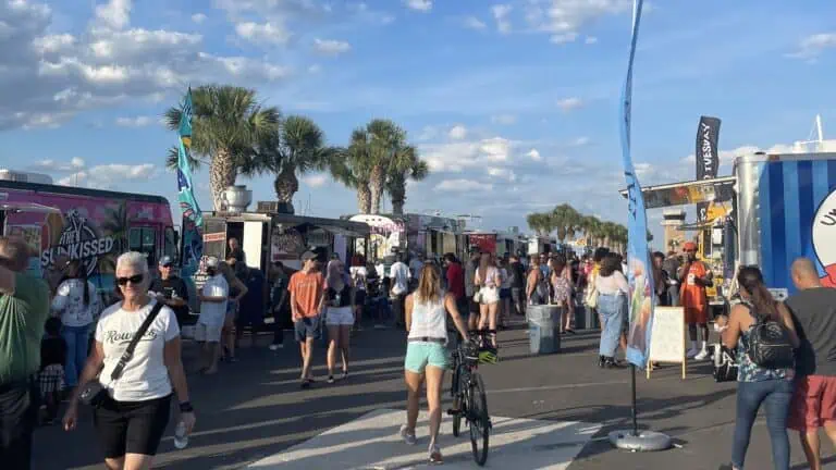 a group of people at a food truck festival at a waterfront park