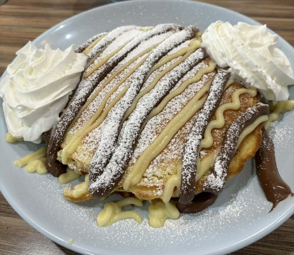 Boston cream pancakes on a plate with whipped cream