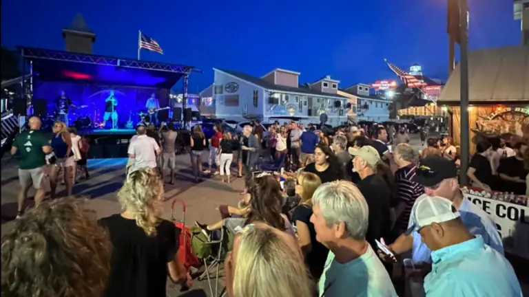 Crowded outdoor area of John's Pass with a stage in center.