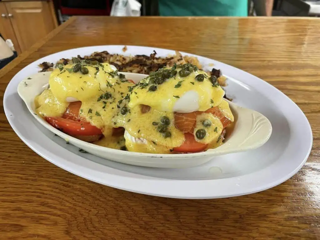 eggs benedict on plate covered with hollandaise sauce