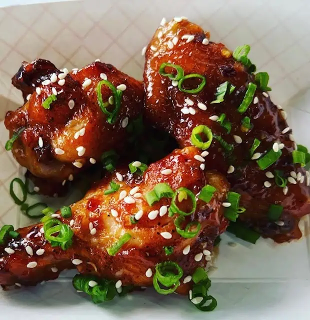 chicken wings covered in sesame seeds and chives