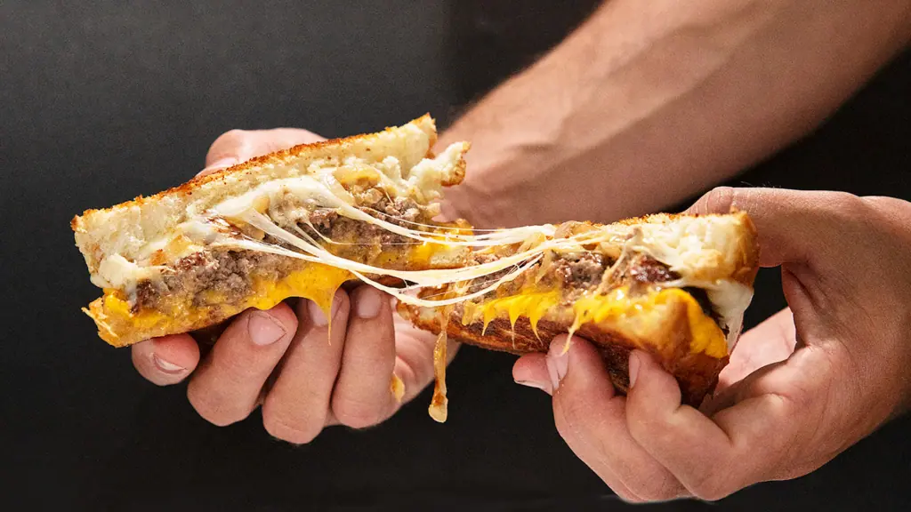 a burger split in half with the cheese stretched out
