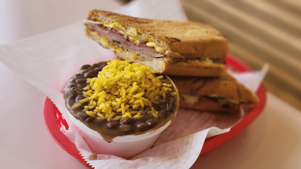 a sandwich plated with rice and beans