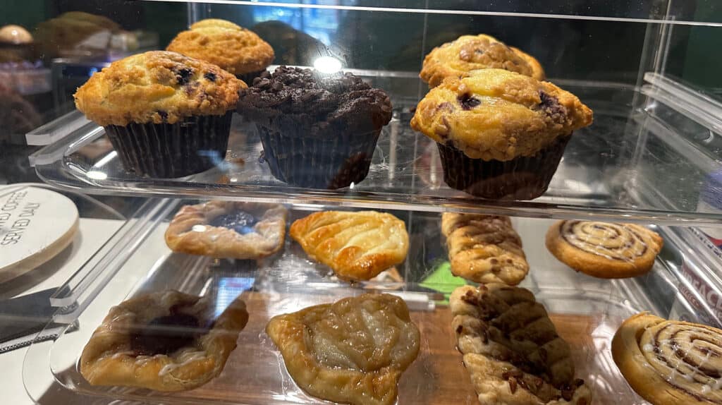 pastry case filled with muffins and chocolate brownies